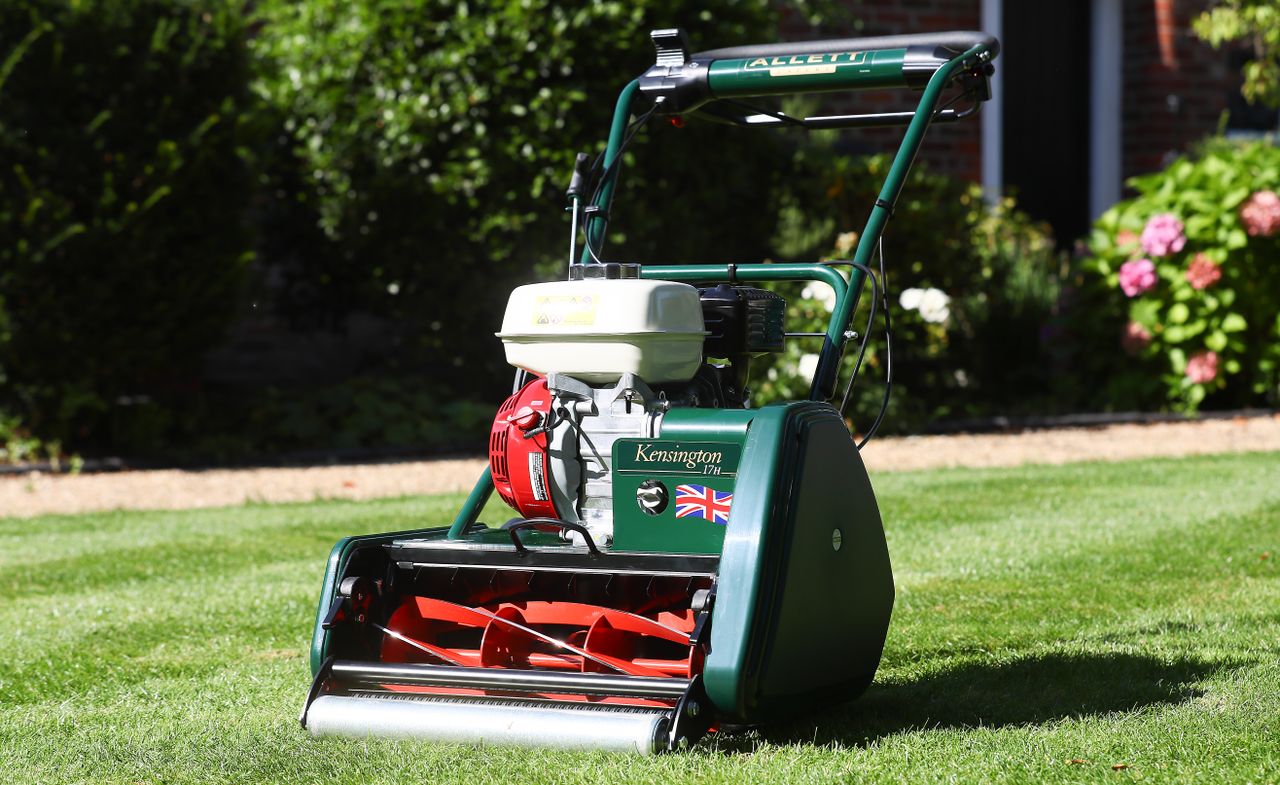 services-02 Premium Allett Kensington lawnmower on a well-manicured garden lawn in summer sunlight.